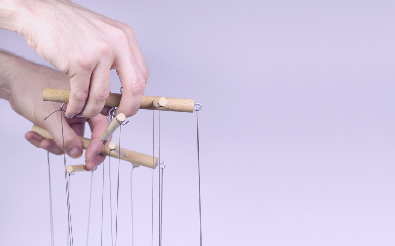 A hand holding a marionette.