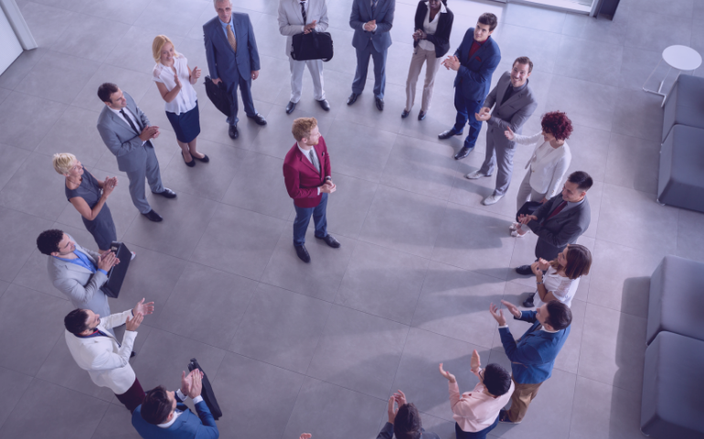 Team lead standing with his team members, having a meeting.