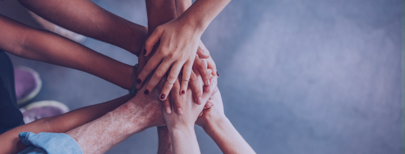 A group of people stacking hands.